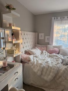 a white bed sitting next to a window in a bedroom