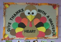 a bulletin board with pictures of turkeys and the words give thanks with a grateful heart