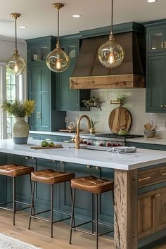 a kitchen with blue cabinets and stools in the center, an island counter has three pendant lights hanging over it