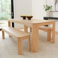 a wooden table with two benches next to it and a bowl of fruit on the table