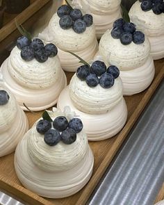 blueberries are on top of white cakes in a bakery