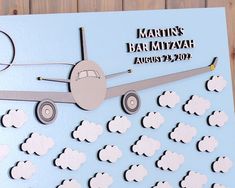 a paper cut out of an airplane with clouds on the side and a name that reads martin's bar mitzvah august 23, 2012