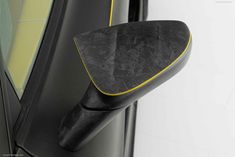 the side view mirror of a car with black and yellow trim