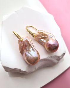 These lustrous, mirror-like glowing large baroque pearl earrings showcase a stunning mix of natural golden, pink, and purple hues in their remarkable shape. The elegant design, coupled with high luster and radiance, makes a statement without being overstated. Perfect for both everyday wear and special occasions, these earrings are a celebration of individuality and uniqueness. ♡ Pearl Earrings FPWE_111_G_1 ♡ ✧ Freshwater Baroque Pearl Earrings ✧ Pearl size: Approx 14mm x 27mm ✧ Natural Pearl Col Baroque Pearl Teardrop Earrings With High Luster, High Luster Baroque Pearl Teardrop Earrings, High Luster Baroque Pearl Drop Earrings, Luxury Baroque Pearl Earrings As Gift, Luxury Baroque Pearl Drop Earrings, Baroque Pearls Jewelry, Tahitian Pearls Jewelry, Gifts For Bride, Silver Pearl Jewelry