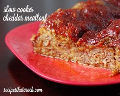 a piece of meatloaf on a red plate with the rest of it cut in half