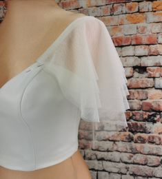 the back of a woman's white top on a mannequin headdress