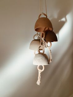 a bell with bells hanging from it's sides on a wall next to a light fixture