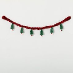 a red string with green christmas trees hanging from it