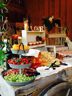 a table filled with lots of food on top of a white cloth covered tablecloth