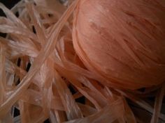 an orange ball sitting on top of some plastic wrap around it's sides and ends