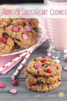 cookies and milk are sitting on a table with pink sprinkles around them