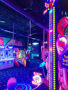 an arcade filled with neon signs and other electronic equipment in the background is a carpeted area