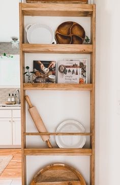 a wooden shelf filled with dishes and utensils