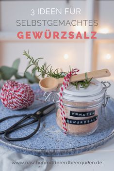 a jar filled with spices sitting on top of a table next to scissors and twine