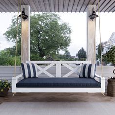 a porch swing with blue and white pillows