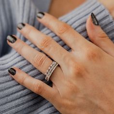 a woman's hand with black and white manicures holding onto her ring