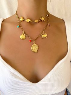 Experience the perfect combination of beachy charm and Greek craftsmanship with our Gold Summer Shell Necklace. Made with vibrant enamel stones and durable stainless steel chains, these handmade necklaces embody the essence of summer. The shorter one is designed as a choker, while the longer one features a stunning gold shell charm at the center. Whether worn together or separately, these necklaces are a must-have for any summer lover. Only available at Christina Christi Store. MATERIALS - Metal Beach Charm Necklace, Scarf Coverup, Rebecca Black, Beach Necklace, Beach Necklaces, Shell Necklace, Shell Pendant, Shell Necklaces, Girls Jewelry