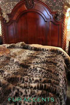 a bed with a wooden headboard and fur on it