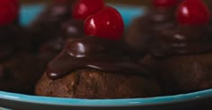 chocolate cupcakes with cherries on top in a blue bowl