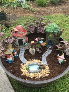 a potted planter filled with lots of plants and small gnome figurines