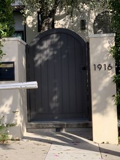 an entrance to a house with a large wooden door and number on the side wall