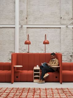 a man sitting on top of a red couch