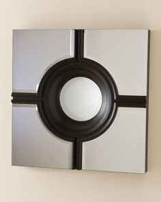 a mirror mounted to the side of a wall next to a black and white object