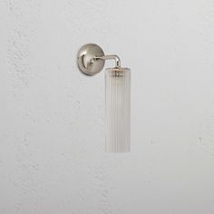 a white wall with a glass light on it