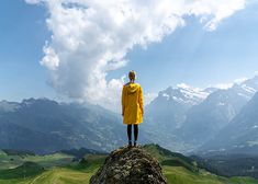 a person standing on top of a rock with mountains in the background