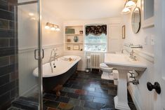 a bath room with a tub a sink and a mirror on the wall in it