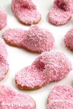 pink powdered doughnuts are arranged on a white surface and ready to be eaten