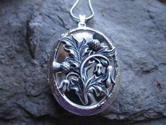 "Beautiful locket choose from silver plated or gold plated. Scotland's national emblem since the 1400's. The thistle has amazing details and is professionally plated and oxidized, to enhance the quality, and completely lead and nickel free. The locket is Victorian style with beautiful etching on both the front and back 2\" long, please see the photos for size. It can hold two photos, keepsakes, or even your daily medication or vitamins. Pass down from generation to generation. The chain is a mat National Emblem, Scottish Thistle, Golden Necklace, Celtic Jewelry, Heart Locket, Character Aesthetic, Victorian Style, Antique Style, Victorian Fashion