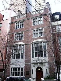 a car parked in front of a tall brick building with two story windows and doors