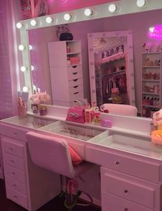 a pink vanity with lights on it in a room