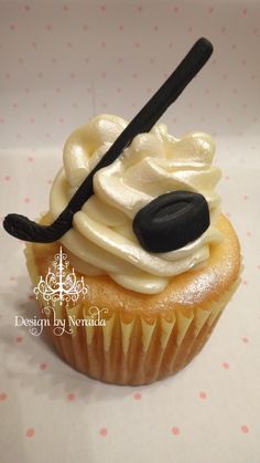 a cupcake with white frosting and black icing