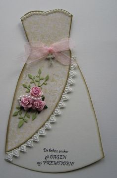 a white card with pink roses on it and a ribbon tied around the neckline