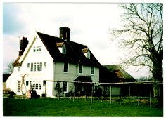 a large white house sitting on top of a lush green field