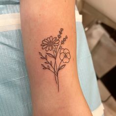 a small flower tattoo on the arm