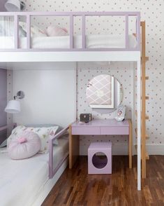 a bedroom with bunk beds and a desk underneath the bed is decorated in pastel colors