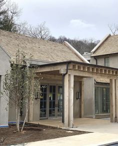 the front entrance to an apartment building with wood shingles on it's roof