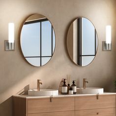 two round mirrors are above the double sink in this modern bathroom with wood cabinets and beige walls