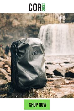 a backpack sitting on top of a rock next to a waterfall with the words cor written