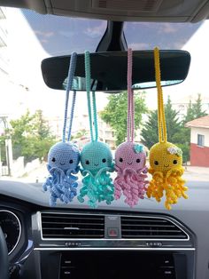 three crocheted octopus keychains hanging from the dash board of a car