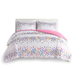 a bed with white sheets and colorful polka dot print on the comforter, along with two pillows