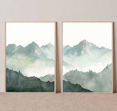 two watercolor mountains are shown on the wall next to each other in this room