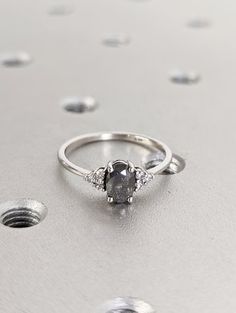 a diamond ring sitting on top of a silver surface with lots of dots around it