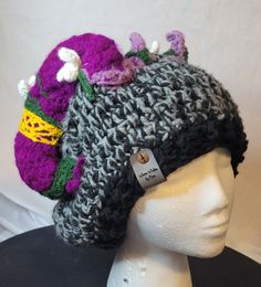 Looking for a whimsical hat? Check out this purple horned hat made with cotton/polyester blends. It is perfect for a renaissance fair, cosplay, or just everyday! With floral and green moss details. Laid flat it is approximately 10.5 in across (with a little stretch), 21in around. Adjustable Purple Hat For Costume, Funky Winter Festival Hats, Hand Knitted Purple Hat, Hand Knitted One Size Purple Hats, Hand Knitted Purple Hat One Size, Hand-knitted One Size Purple Hat, Purple Hat For Festivals, Purple One Size Fits Most Festival Hat, Fitted Costume Hats And Headpieces For Winter Festival