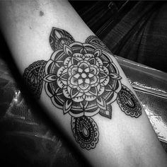 a black and white photo of a tattoo design on the arm with an intricate flower