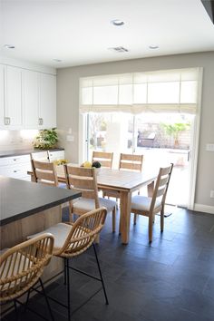 a dining room table and chairs in front of a sliding glass door