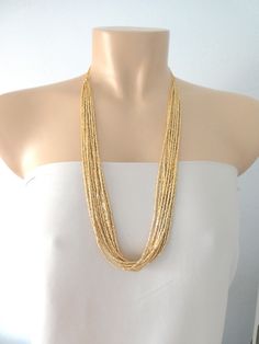 "Long necklaces for women boho layered. Measures 30\". It has 12 strands. ❤ PROCESSING AND SHIPPING Most orders are made and shipped out in one business day. Please check delivery timeframes for your location on the description below. ❤ CUSTOM ORDERS If you like this item in a different color, send me a message indicating: color, size and quantity needed. I will send you a link for a \"custom order\" and you'll be able to place the order there. If you like this item with some variations such as Gold Long Beaded Necklace, Gold Multi-strand Beaded Chain Necklace, Gold Multi-strand Layered Necklace With Beads, Gold Multi-strand Chain Necklace, Gold Multi-strand Necklace With Gold Beads, Gold Beaded Chain Layered Necklace, Gold Beaded Multi-strand Layered Necklace, Gold Multi-strand Beaded Necklaces With Tiny Beads, Gold Double Strand Beaded Necklaces With Tiny Beads